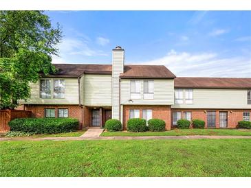 Charming townhouse featuring a brick foundation, siding and manicured bushes, under a sunny blue sky at 3184 Nectarine Cir, Decatur, GA 30034