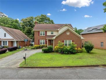 Charming brick two-story home with a well-maintained lawn and mature trees at 1237 Hunters Dr, Stone Mountain, GA 30083