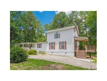 Charming two-story home featuring a spacious front yard and a side deck with wooden stairs at 5365 Winding Ln, Suwanee, GA 30024