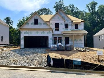 Two-story new construction home with a two-car garage and covered front porch, under construction at 727 Crest Line Trl, Powder Springs, GA 30127