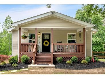 Charming home exterior featuring a cozy front porch with wood railings and a welcoming yellow wreath at 428 Hulseytown Rd, Dallas, GA 30157