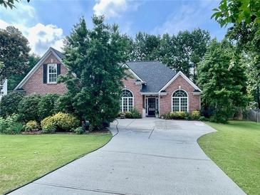 Charming brick home with lush landscaping and an inviting driveway at 1902 Commons View Cir, Snellville, GA 30078