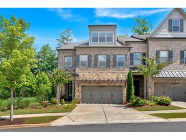 Beautifully landscaped home with stone accents, attached two-car garage, and charming curb appeal at 1099 Heyward Way, Alpharetta, GA 30009