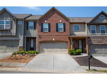 Charming townhome features brick accents, a two-car garage, and a well-maintained front yard in a desirable neighborhood at 3325 Castleberry Village Cir, Cumming, GA 30040