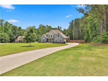 Charming two-story home with a lush green lawn and long driveway at 33 Vinery Ct, Sharpsburg, GA 30277