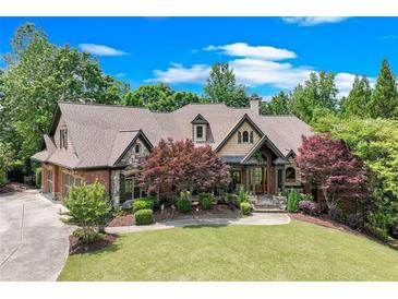 Charming two-story home with beautiful lawn and landscaped yard with brick and stone exterior accents at 5623 Brendlynn Dr, Suwanee, GA 30024