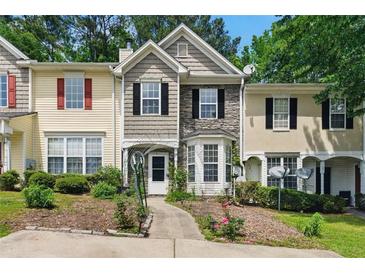 Charming townhome with stone accents, manicured landscaping, and inviting walkway to a cozy front porch at 1689 Camden Forrest Way, Riverdale, GA 30296