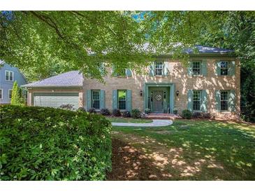Charming two-story brick home featuring well-maintained landscaping and a welcoming facade at 2982 Huntshire Pl, Atlanta, GA 30340