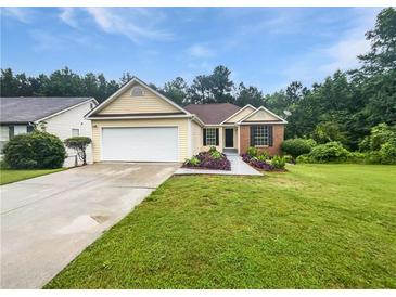 Charming single-story home boasts a well-manicured lawn and a two-car garage at 6560 Alford Way, Lithonia, GA 30058