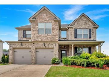 Beautiful two-story brick home with a three car garage and landscaped front yard at 2239 Noelle Pl, Powder Springs, GA 30127