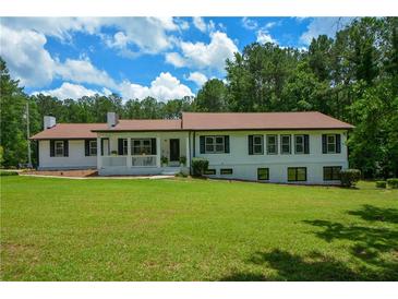 Charming ranch home featuring a welcoming front porch and lush lawn at 871 Cowan Se Rd, Conyers, GA 30094