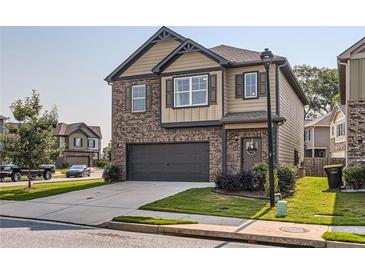 Charming two-story home with brick and siding, showcasing a well-maintained front yard and attached two-car garage at 11910 Brightside Pkwy, Hampton, GA 30228
