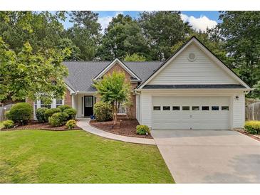 Charming single-story home featuring a well-manicured lawn and an attached two-car garage at 1865 Morgans Run Trl, Buford, GA 30519