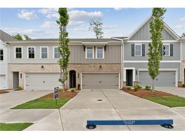 New construction townhomes with brick and siding exteriors, garages and well manicured lawns at 113 Priestwood Ln, Acworth, GA 30102