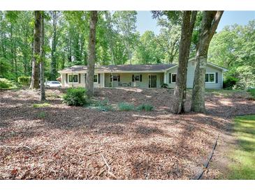 Charming single-story home with a well-maintained lawn, surrounded by mature trees at 1379 Branchwood Dr, Snellville, GA 30078