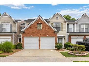 Charming townhome featuring a two-car garage and well-maintained landscaping at 113 Regent Pl, Woodstock, GA 30188