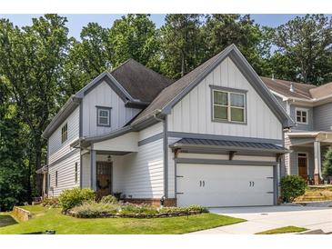 Charming two-story home featuring white siding, gray trim, a two-car garage, and a beautifully landscaped front yard at 1753 Russell Se St, Atlanta, GA 30316