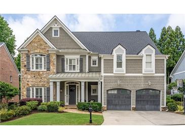 Charming home featuring stone and shingle siding, a manicured lawn and an attached two-car garage at 1075 Bluffhaven Way Northeast Ne Way, Atlanta, GA 30319