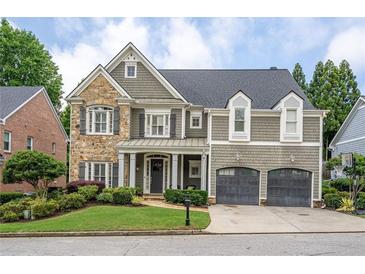 Charming two-story home featuring a stone facade, shingle siding, a two-car garage and manicured landscaping at 1075 Bluffhaven Way Northeast Ne Way, Atlanta, GA 30319