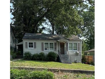Charming single-story home with gray exterior, shuttered windows, and a front porch, surrounded by mature trees at 213 Birch St, Hapeville, GA 30354