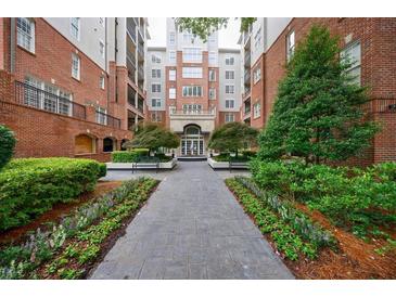 Beautiful courtyard of a brick apartment building with landscaped flower beds and walkway to the main entrance at 50 Biscayne Nw Dr # 4110, Atlanta, GA 30309