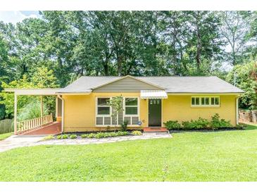 Charming brick home with well-manicured lawn, mature trees, and inviting carport at 3467 Pinehill Dr, Decatur, GA 30032