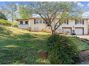 Charming home featuring a well-maintained yard, red shutters and two-car garage at 945 Blackwell Rd, Marietta, GA 30066