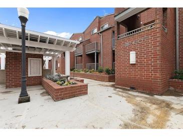 Inviting brick townhouse exterior featuring landscaped courtyard, private balconies, and well-maintained walkways at 387 Ralph Mcgill Ne Blvd # K, Atlanta, GA 30312