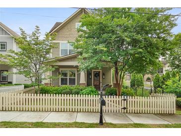 Charming two-story home with a welcoming front yard, lush landscaping, and a classic white picket fence at 1184 Medlin Se St, Smyrna, GA 30080