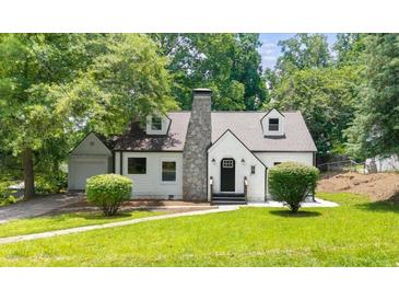 Charming home with stone chimney, white exterior, manicured lawn, and mature trees at 1366 Allegheny Sw St, Atlanta, GA 30310