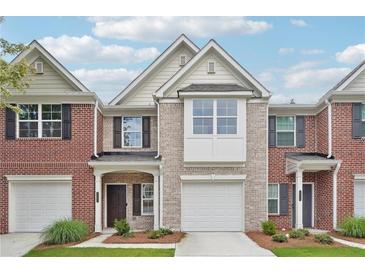 Charming brick townhome featuring a one-car garage and a neatly landscaped front yard at 2357 Heritage Park Nw Cir # 17, Kennesaw, GA 30144
