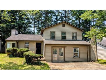 Charming two-story home with a well-maintained front yard surrounded by lush trees at 2015 Corners Cir, Lithonia, GA 30058
