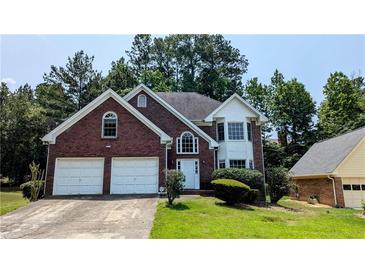 Charming two-story brick home with well-manicured lawn and attached two-car garage at 6385 Southland Forest Dr, Stone Mountain, GA 30087