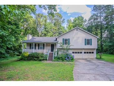Charming home featuring a covered front porch, attached two car garage, and lush landscaping at 2140 Deer Trl, Suwanee, GA 30024