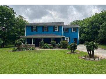 Two-story blue house with black shutters and a covered front porch offers an inviting curb appeal at 5560 Old Bill Cook Rd, College Park, GA 30349