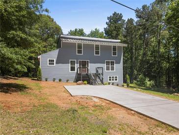 Charming two-story home with a modern metal roof and a freshly poured concrete driveway at 2158 Huckleberry Ln, Lithia Springs, GA 30122