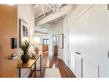 Hallway featuring hardwood floors, stylish decor, and access to various rooms including the living area and bathroom at 878 Peachtree Ne St # 704, Atlanta, GA 30309