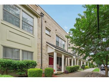 Charming brick townhouse with covered porch, manicured bushes, and lush green tree at 190 Marion Ne Pl, Atlanta, GA 30307