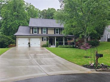 Traditional two-story home featuring a manicured lawn, a cozy front porch and a two car garage at 2263 Hill Creek Way, Marietta, GA 30062