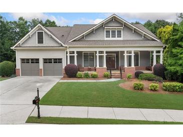Charming single-Gathering home featuring a large front porch, two-car garage, and beautifully landscaped front yard at 3157 Perimeter Cir, Buford, GA 30519