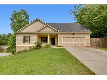 Charming home features a manicured lawn and a two-car garage at 3792 Refinement Way, Douglasville, GA 30135