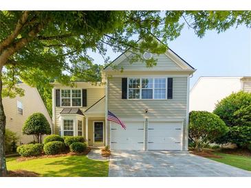 Charming two-story home featuring a well-maintained lawn and a two-car garage at 306 Burdock Trce, Woodstock, GA 30188