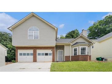 Charming two-story home showcasing a two-car garage, brick accents and siding, complete with a well-maintained lawn at 4400 Old Allgood Cir, Stone Mountain, GA 30083