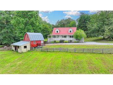Charming farmhouse with red roof, barn, sprawling yard, and fenced perimeter at 1365 Lower Creighton Rd, Cumming, GA 30028