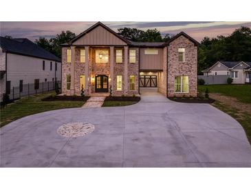 Striking brick exterior with grand entrance, circular driveway, and attached two-car garage at 157 Shadburn Ferry Rd, Buford, GA 30518