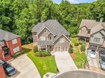 Beautiful craftsman home featuring well-manicured lawn, three-car garage, and mature trees in a desirable neighborhood at 931 Hidden Falls Se Ln, Smyrna, GA 30082