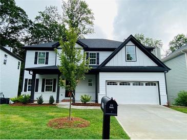 Beautiful two-story home featuring modern white siding, black trim, and a well-manicured lawn at 1540 Ox Bridge Ct, Lawrenceville, GA 30043