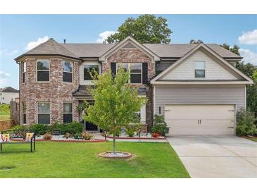 Charming two-story home with a brick facade, well-manicured lawn, and attached two-car garage at 3126 Cove View Ct, Dacula, GA 30019