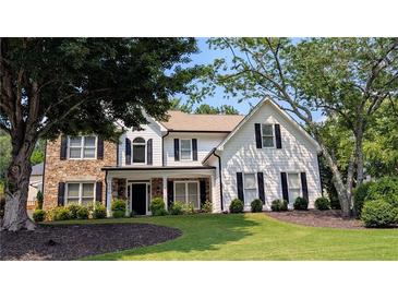 Charming two-story home with black shutters, stone accents, and a beautifully landscaped front yard at 300 Windsor Chase Trl, Johns Creek, GA 30097