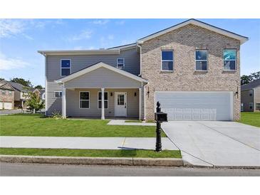 Charming two-story home features a combination of brick and siding, a two-car garage, and a well-manicured lawn at 3634 Oakleaf Pass, Fairburn, GA 30213
